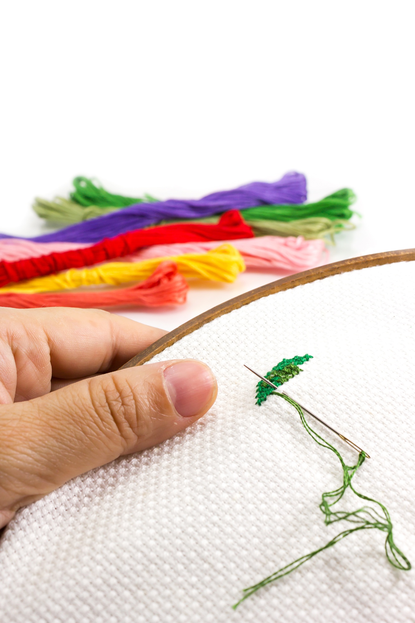 Close-up of hand embroidery on linen with vibrant threads